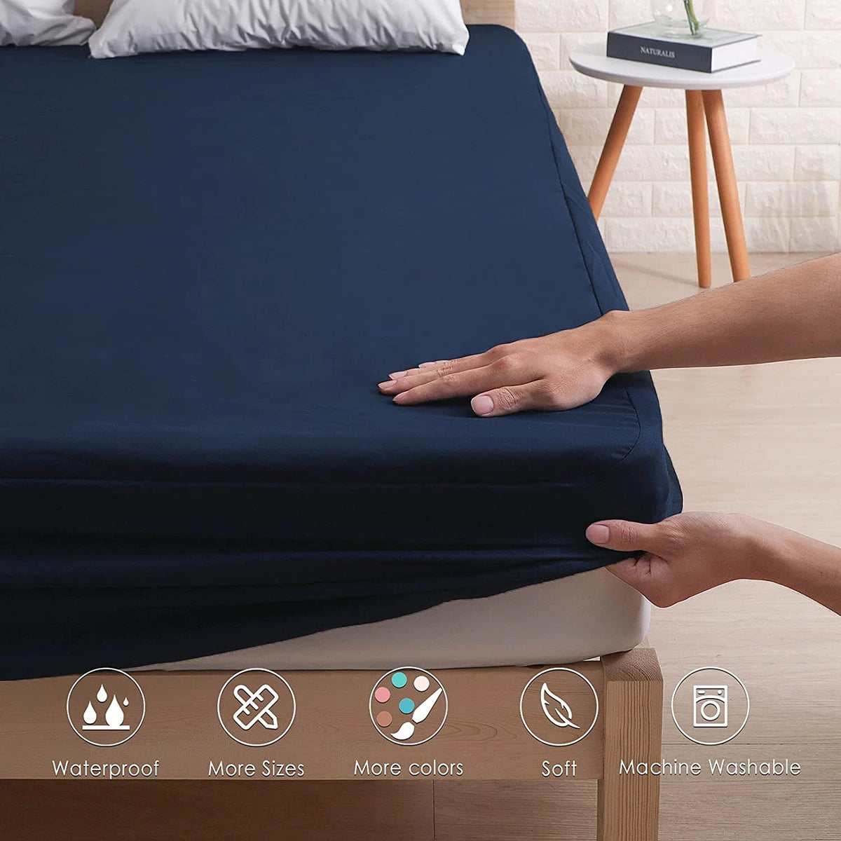 Person installing navy waterproof fitted mattress cover on bed corner
