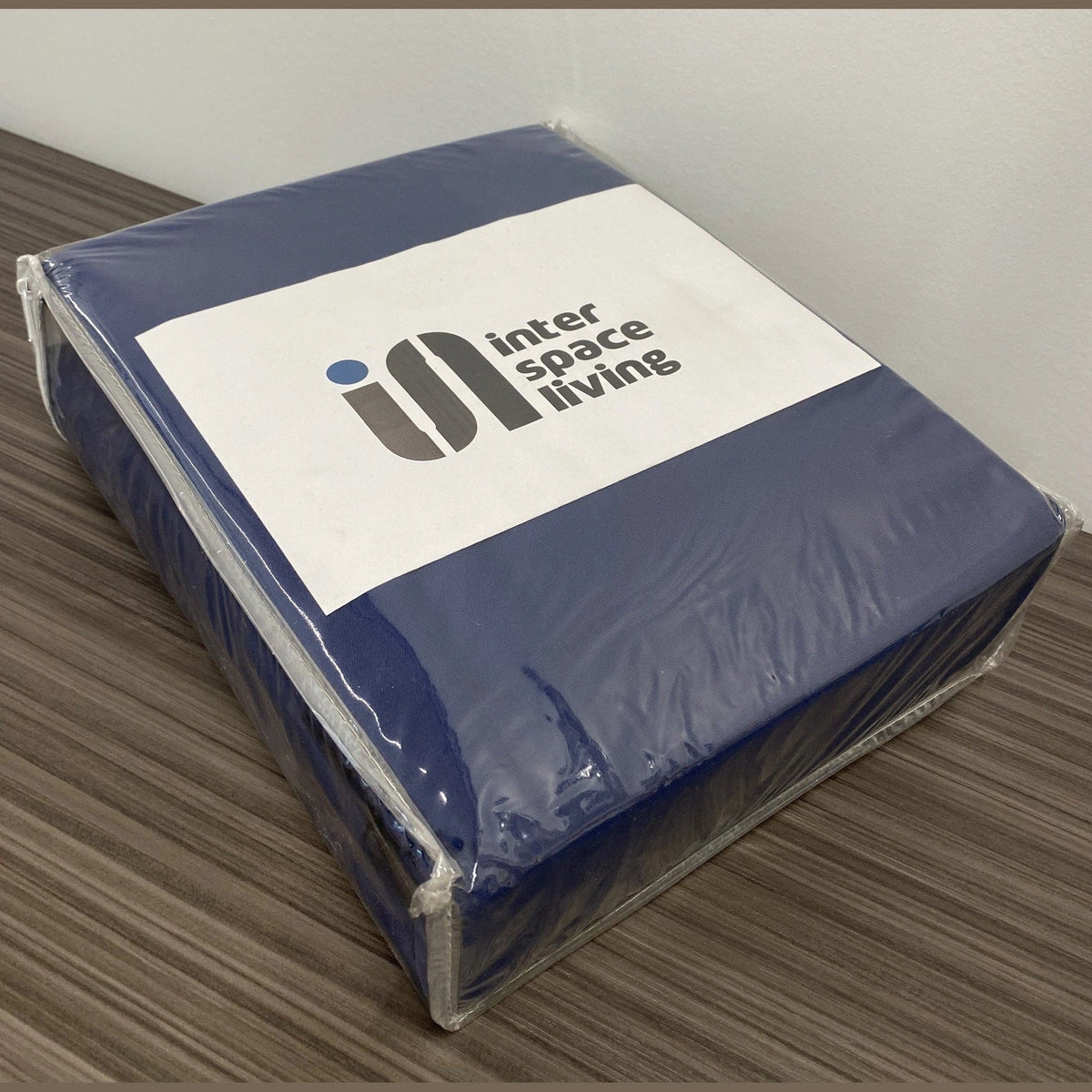 Navy blue mattress cover in clear plastic packaging with InterSpaceLiving label
